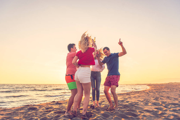 Grupo de amigos disfrutan en la playa
 - Foto, imagen