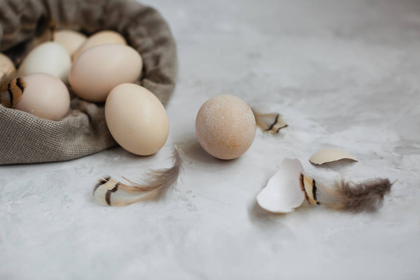 Huevos de Pascua en una bolsa de lona sobre un fondo gris
. - Foto, Imagen