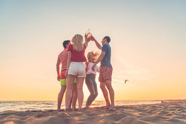 Gruppo di amici godono sulla spiaggia
 - Foto, immagini