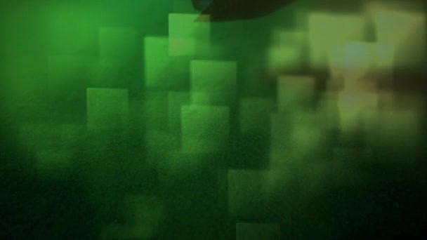 Digital composite of five cards falling on the ground against a green background. Light green colored cubes move on the foreground - Video, Çekim