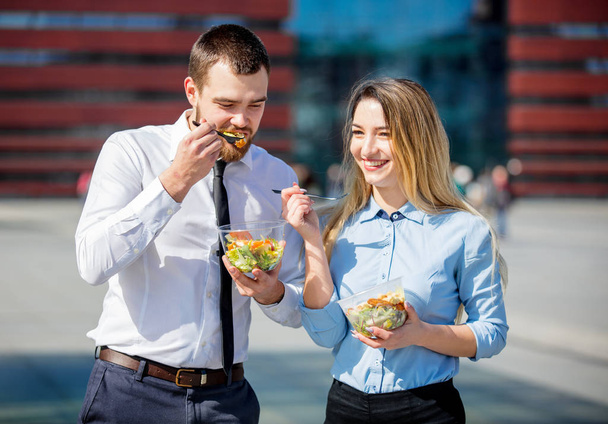 joven mujer de negocios y hombre de negocios comiendo juntos ensalada
 - Foto, Imagen