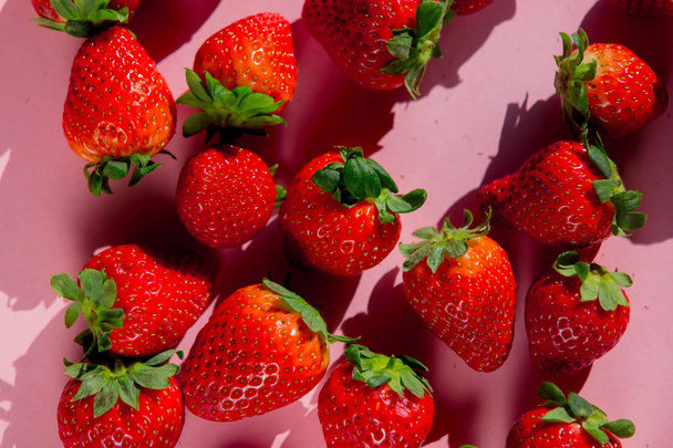 Group of fresh strawberries on pink background. Above view - Zdjęcie, obraz