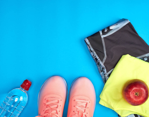 Women's clothing set for fitness on a blue background - Foto, Bild