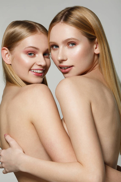 Two beautiful half naked blonde female models with perfect skin - Fotó, kép