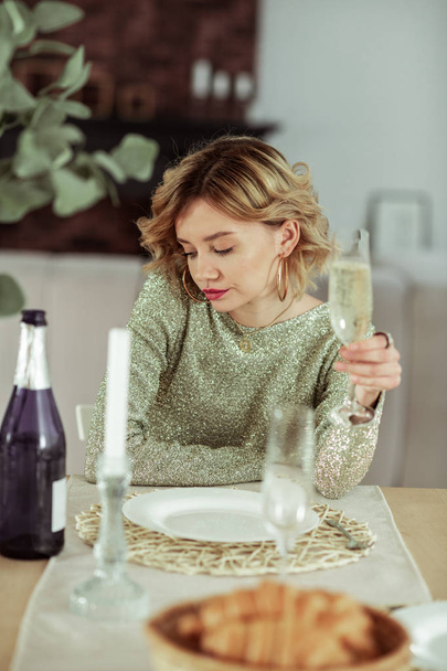 Mujer sentada a la mesa con croissants y champán sola
 - Foto, Imagen
