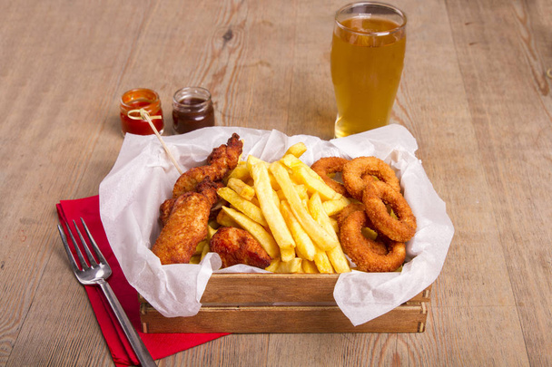στενή εικόνα της άχρηστα τρόφιμα και μπύρα σε ξύλινο τραπέζι - Φωτογραφία, εικόνα