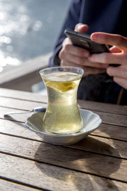 μερική θέα του ανθρώπου και κούπα ζεστό αρωματικό τσάι - Φωτογραφία, εικόνα