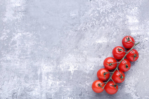 Cherry tomatoes on grey wooden table - Фото, зображення