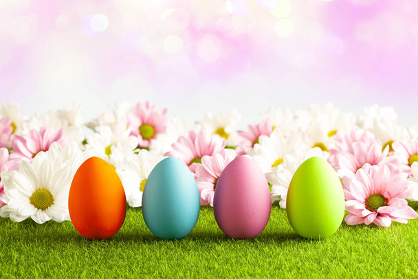 Easter eggs on the grass and pink abstract background - Foto, Imagen