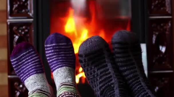 Des pieds d'homme et de femme en chaussettes tricotées en laine dansent près de la cheminée. Concept de saison hivernale
. - Séquence, vidéo