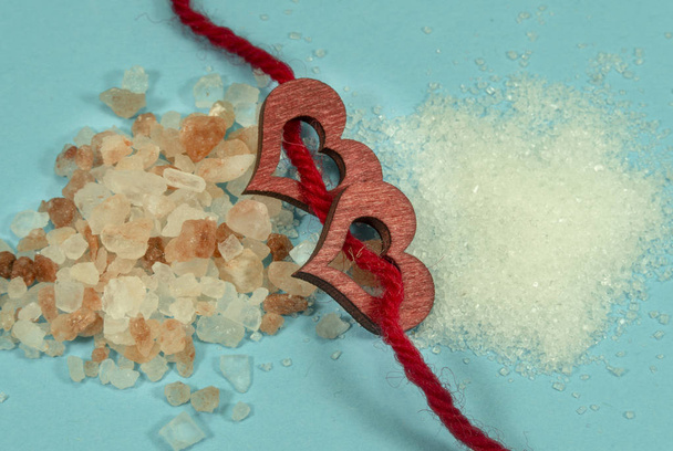 Два деревянных декоративных сердца, нанизанных на красную веревку
 - Фото, изображение