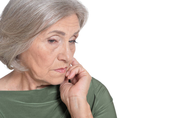 Портрет грустной пожилой женщины на белом фоне
 - Фото, изображение