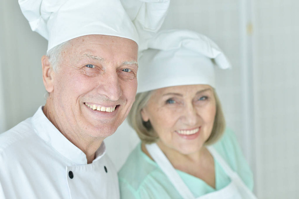 couple of smiling Senior chefs at kitchen   - Foto, Imagem