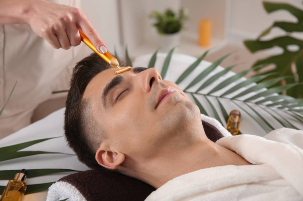 Man receiving face massage in beauty salon - Фото, изображение