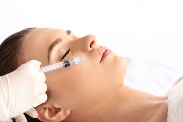 Young woman receiving filler injection in beauty salon - Foto, Imagem