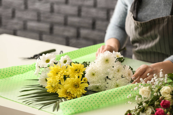 schöne Floristin arbeitet am Tisch im Geschäft - Foto, Bild