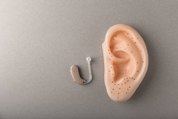 Слуховий апарат і модель вуха на сірому фоні
 - Фото, зображення