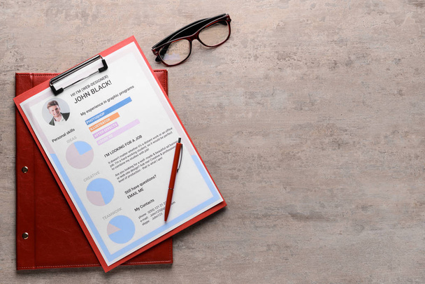 Job resume with eyeglasses on grey table - Photo, Image