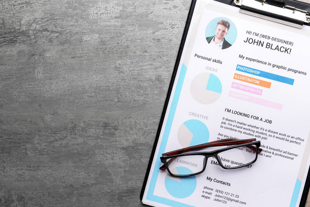 Job resume with eyeglasses on grey table - Photo, Image