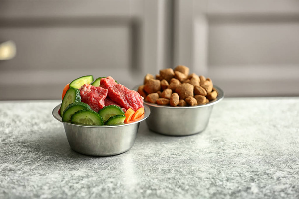 Cuencos con comida seca y fresca para mascotas en la mesa
 - Foto, imagen