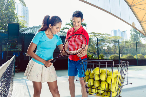 Tenisz oktató oktatás a megfelelő markolat a gazdaság az ütő - Fotó, kép