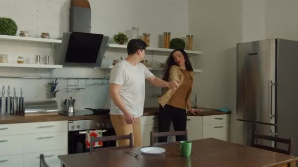 Angry man hurting woman grabbing hand in kitchen - Záběry, video