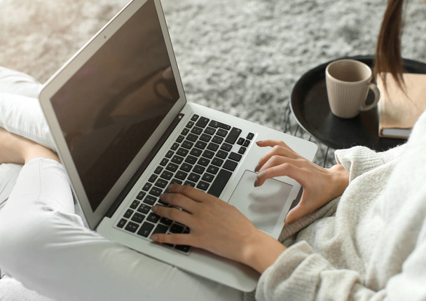 Kaunis nuori nainen käyttää kannettavaa tietokonetta kotona, lähikuva
 - Valokuva, kuva