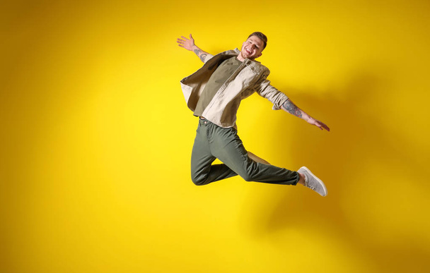 Handsome jumping man against color background - Photo, image