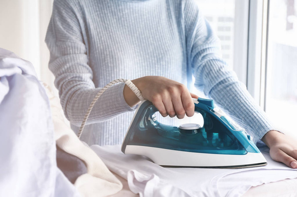 Young woman ironing clothes at home - Valokuva, kuva