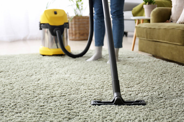 Woman cleaning carpet with hoover at home - Photo, Image
