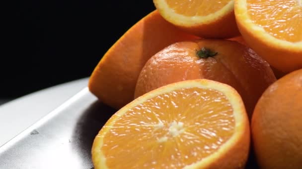 Naranjas frescas y naturales cortadas y giratorias enteras en una bandeja negra
 - Imágenes, Vídeo