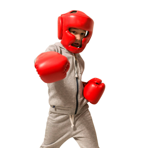 Спортивный мальчик делает упражнения по боксу, наносит прямой удар. Фотография y
 - Фото, изображение