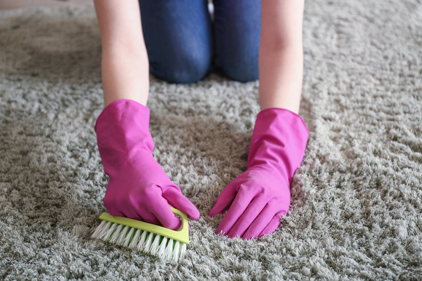 Woman cleaning carpet at home - 写真・画像