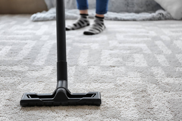 Woman cleaning carpet with hoover at home - Foto, Imagem