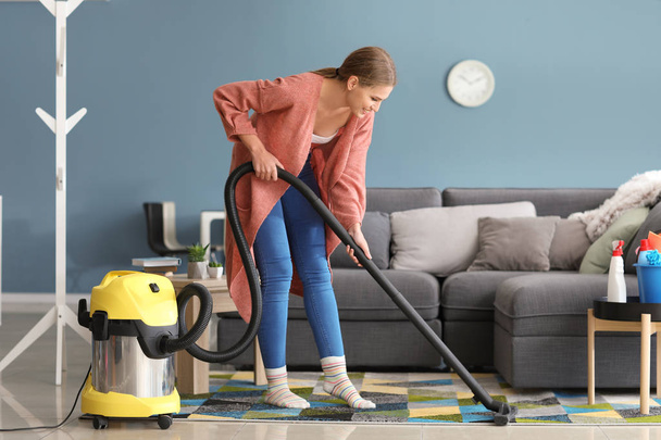 Beautiful woman with vacuum cleaner at home - Foto, immagini