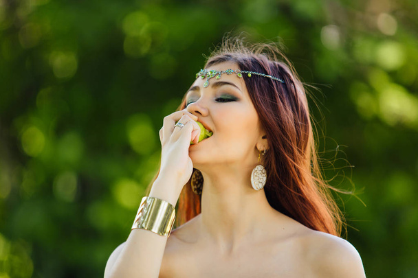 Beautiful young asian woman eating fresh kiwi - Фото, изображение