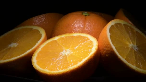 Πορτοκάλια κομμένα φρούτα gyrating με μαύρο φόντο - Πλάνα, βίντεο