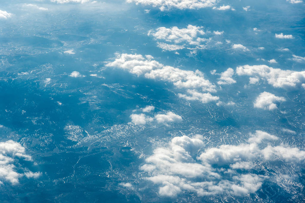 Вид зверху на білі хмари над землею або водою
 - Фото, зображення