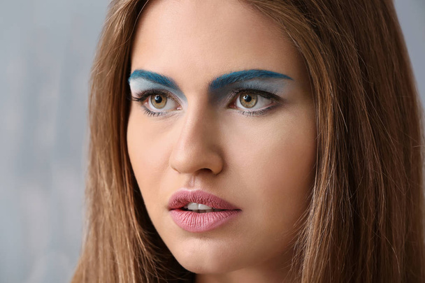 Beautiful young woman with bright makeup on grey background, closeup - Zdjęcie, obraz