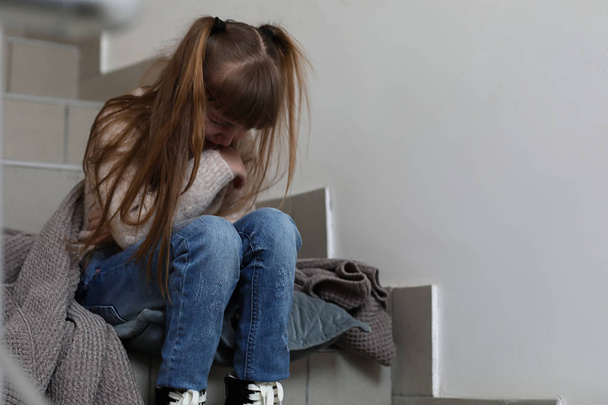 Itkevä pikkutyttö istuu portaissa
 - Valokuva, kuva