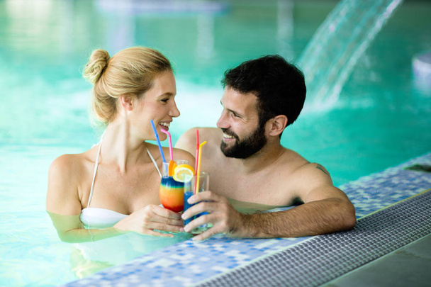 Happy attractive couple relaxing in spa swimming pool - Zdjęcie, obraz