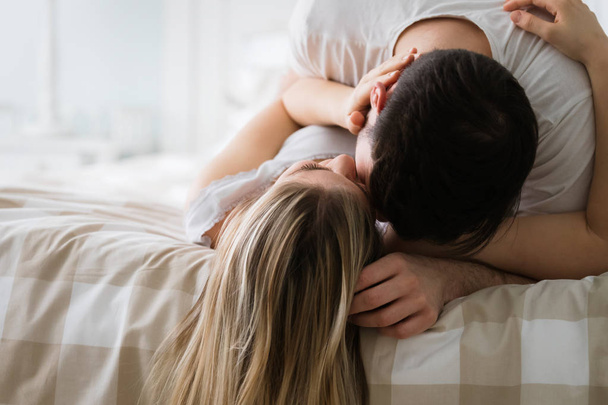 Portrait of young attractive loving couple in bedroom - Photo, Image
