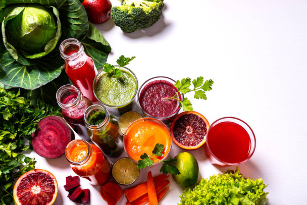 Diferentes bebidas veganas saudáveis com frutas e legumes no fundo de madeira branca. Depósito plano
. - Foto, Imagem