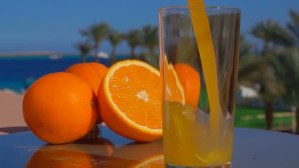 Zbliżenie świeżego soku pomarańczowego wlewa się do szklanki - Materiał filmowy, wideo