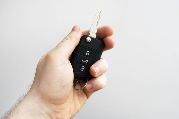 Mano masculina sosteniendo las llaves del coche. Lugar para el texto
. - Foto, Imagen