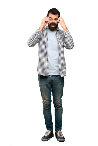 Pohledný muž s plnovousem, s brýlemi a překvapen nad izolované bílým pozadím - Fotografie, Obrázek