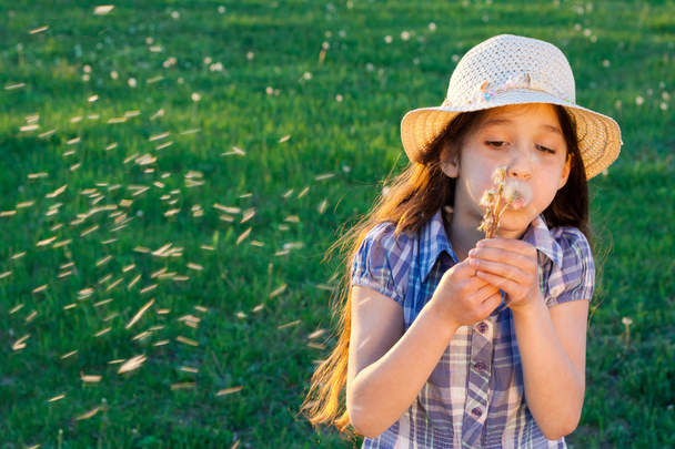 Girl blowing to dandelion - Foto, afbeelding