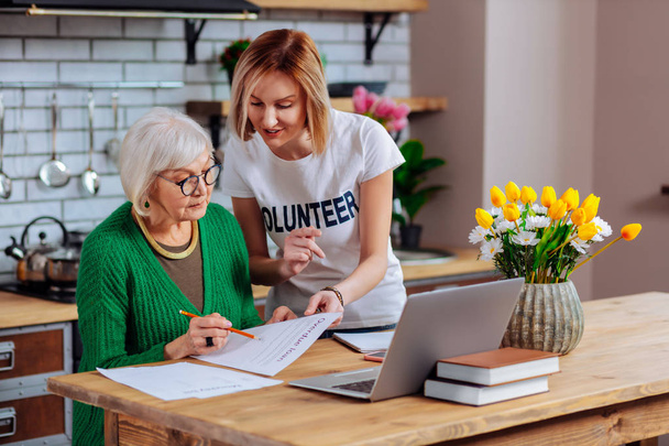 Volunteer trying to persuade elderly woman to sign overdue loan - Fotografie, Obrázek