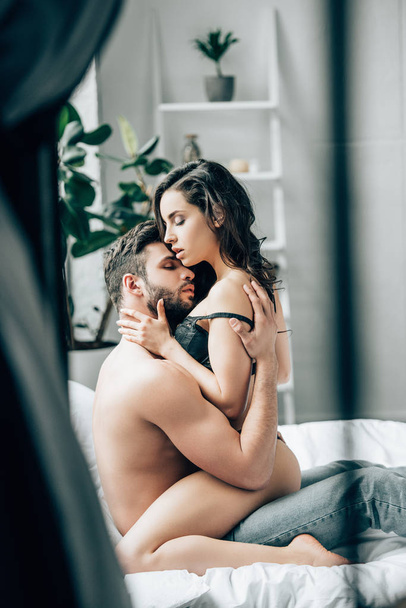 selective focus of shirtless man touching attractive brunette girl in underwear   - Fotografie, Obrázek
