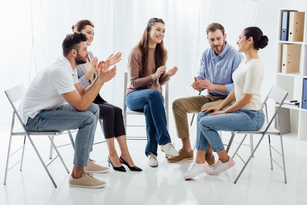 Grupa ludzi siedzi na krzesłach i brawo podczas sesji terapii - Zdjęcie, obraz